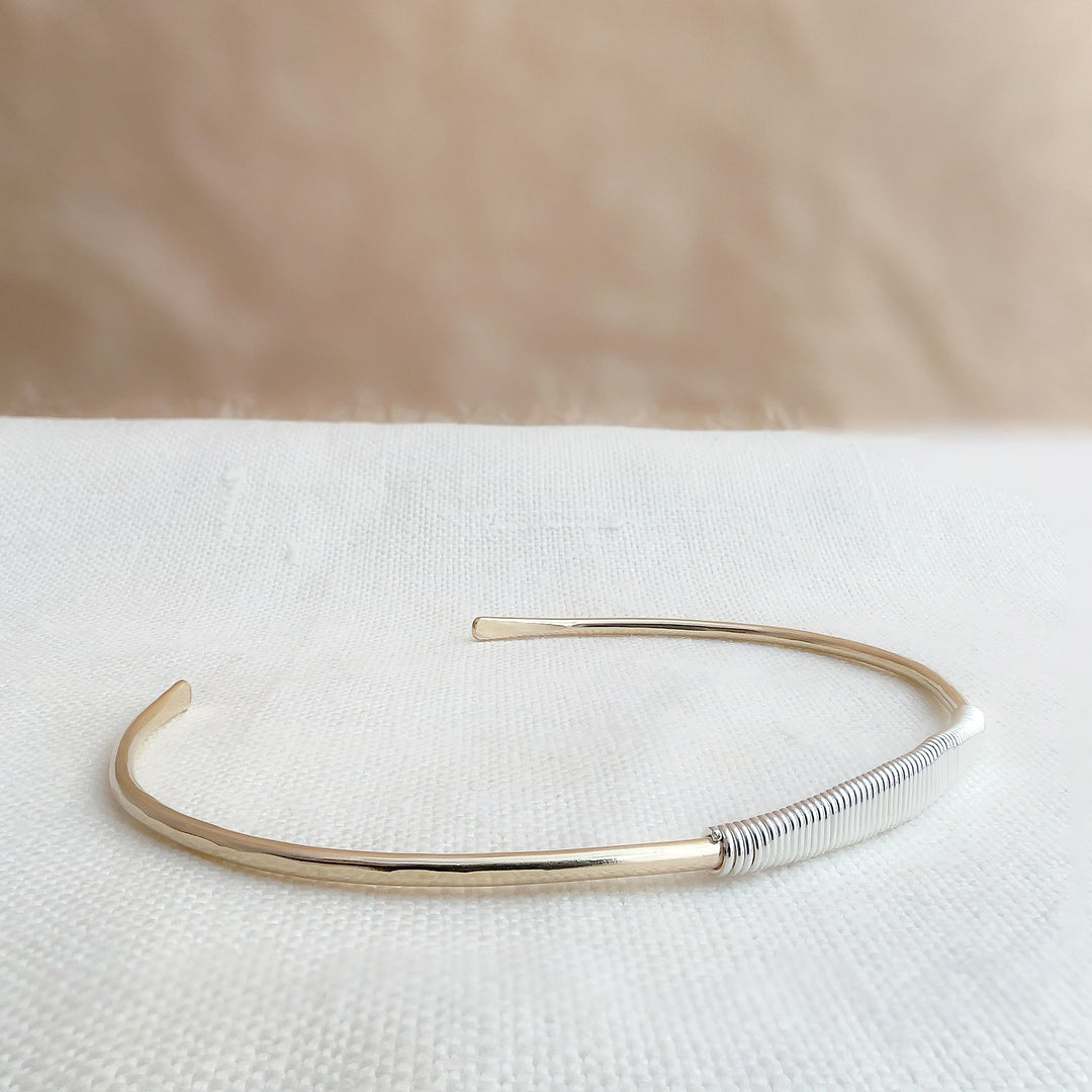 HELIX two-tone faceted cuff bracelet in 14K gold fill with sterling silver wire wrap, lying flat